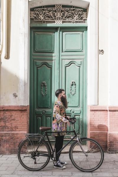 Fashionable Young Man with Bicycle in Front of Green Door – Free Download