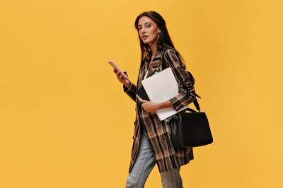 Brunette Woman in Oversized Jacket and Jeans with Phone and Notebooks – Free Stock Photo for Download