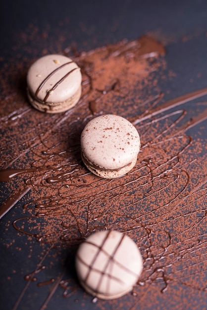 Chocolate Powder and Syrup on Macaroons Against a Black Backdrop – Free Download