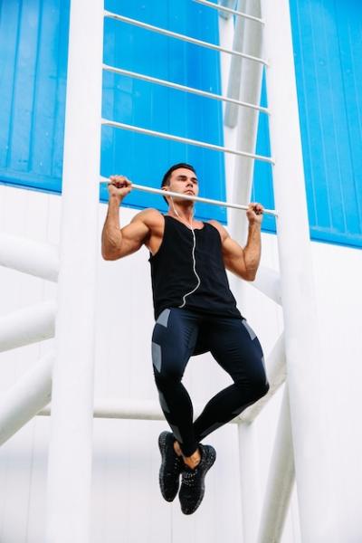 Motivated Sportsman Doing Pull Ups While Listening to Music – Free Download