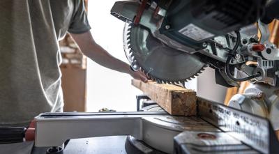 A Professional Carpenter Using a Circular Miter Saw in a Workshop – Free Stock Photo, Download Free