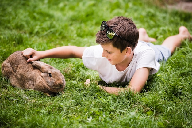 Boy Lying on Green Grass Enjoying Time with His Rabbit – Free Stock Photo, Download Free