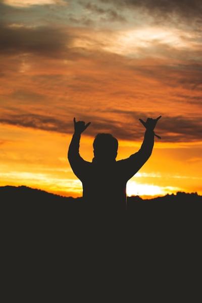 Silhouette of a Man Making a Sign with Fingers Against a Colorful Sunset Sky – Free Stock Photo, Download for Free