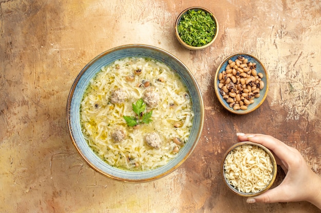 Azerbaijani Erishte in a Bowl: Womanâs Hand with Various Ingredients on Beige Background – Free Stock Photo, Download for Free