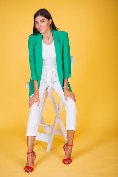 Woman in Green Jacket Sitting on Chair Against Yellow Background – Free Stock Photo, Download for Free