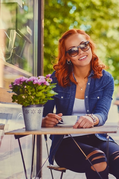 Redhead Woman in Sunglasses Enjoying Coffee at a Street Cafe – Free Download