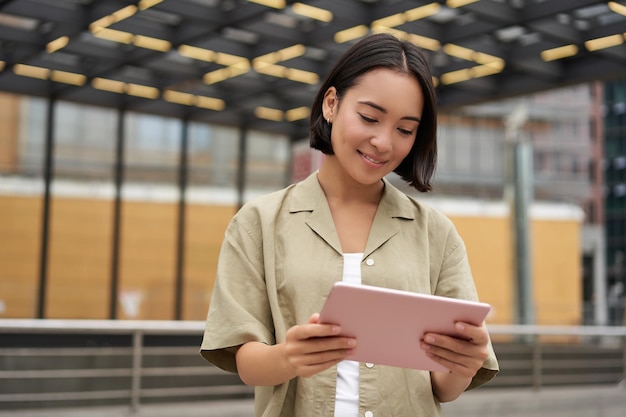 Beautiful Asian Girl Reading on Tablet While Standing on Street – Free Stock Photo, Download Free