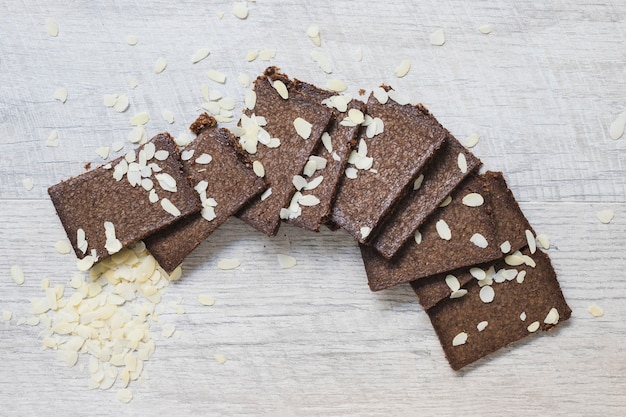 Slices of Chocolate Bars and Almonds on White Wooden Textured Backdrop – Free Download