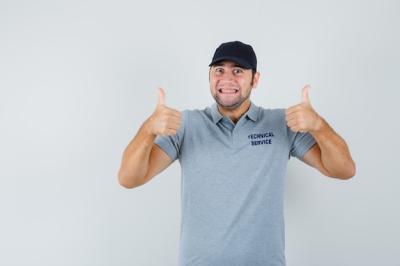 Cheerful Young Technician in Uniform Giving Double Thumbs Up – Free Stock Photo for Download