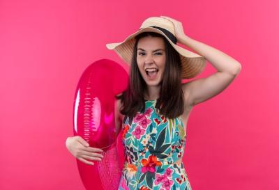 Confident Young Woman with Swim Ring and Hat on Pink Background – Free Stock Photo for Download