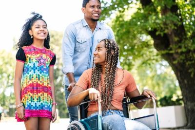 An African American Woman in a Wheelchair Enjoying a Walk Outdoors with Her Daughter and Husband – Free to Download