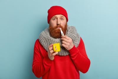 Sick man in warm clothes with thermometer and cup – Free Stock Photo for Download