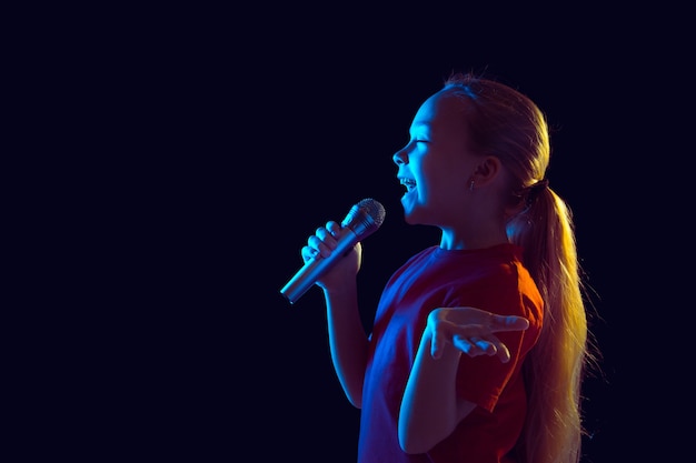 Singing Happy: Portrait of a Caucasian Girl in Neon Light with a Speaker – Free to Download