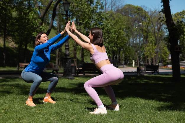 Two Women in Sportswear Enjoying a Sunlit Workout in the Park – Free Download