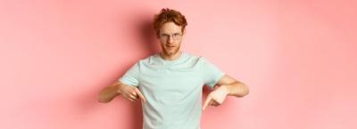 Confident Redhead Man in Glasses Pointing Fingers Down – Free Stock Photo for Download