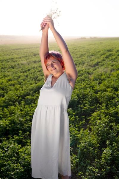 Confident Young Woman Posing Outdoors in a Field with Armpit Hair – Free Stock Photo for Download