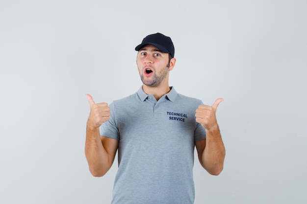 Happy Young Technician in Uniform Giving Double Thumbs Up – Free Download