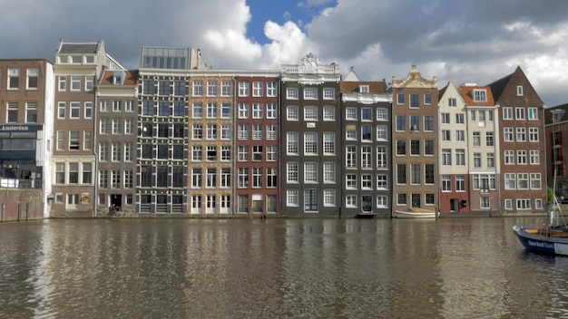 Grand Historical Buildings and Reflections Along the Damrak Canal in Amsterdam Holland – Free Stock Photo Download