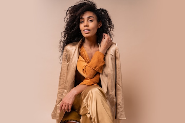 Elegant Woman in Orange Blouse and Silk Pants on Vintage Chair – Free Download, Free Stock Photo