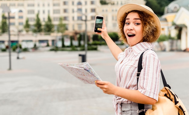 Shocked Woman Holding a Map and a Phone – Free Download