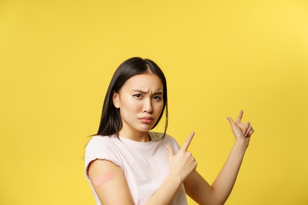 Disappointed Asian Girl Pointing at Covid-19 Vaccination Promo Banner – Free Download