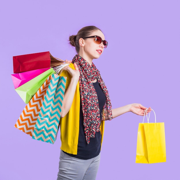 Fashionable Young Woman with Shopping Bag Over Purple Backdrop – Free Stock Photo for Download