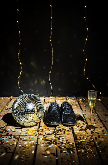 Disco Ball, Man’s Boots, and Glass of Drink Amidst Confetti – Free Download