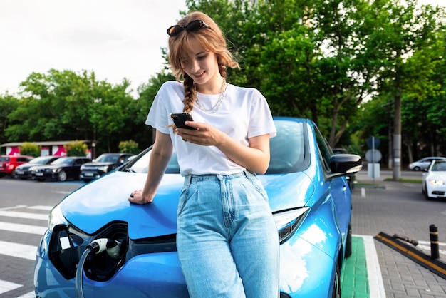 Young Woman at Electric Car Charging Station in Chisinau, Moldova – Free Download