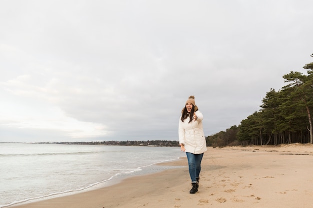 Cheerful Woman on Shore Pointing at Camera – Free Download