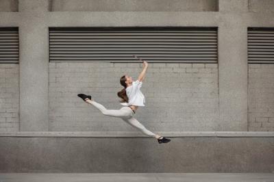 Jumping Young Woman in Front of City Building Wall – Free Stock Photo for Download