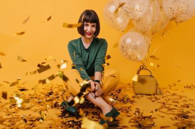 Cheerful European Lady in Green Sweater Surrounded by Confetti – Free to Download