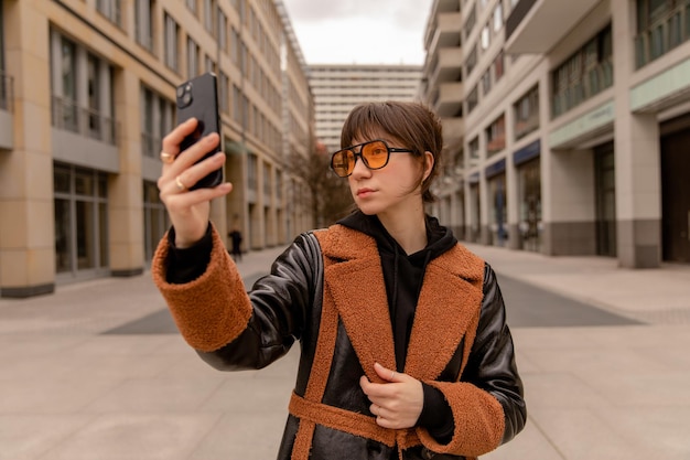 Woman on Street Checking Phone in Orange Sunglasses – Free Stock Photo Download