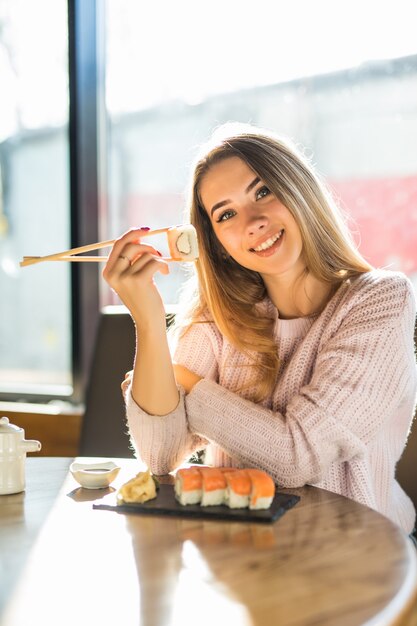 Girl Enjoying Sushi for Lunch in a White Sweater – Free Stock Photo for Download