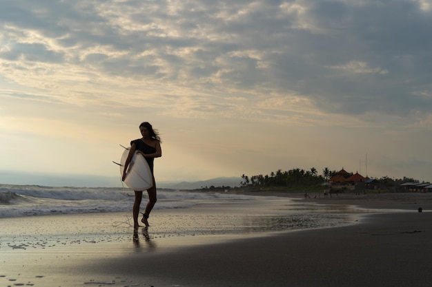 Woman Surfer with Surfboard on the Ocean at Sunset – Free Stock Photo Download