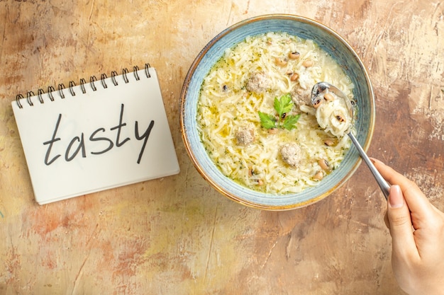 Azerbaijani Erishte Spoon in Woman’s Hand with Bowl and Tasty Notes on Beige Background – Free Stock Photo Download