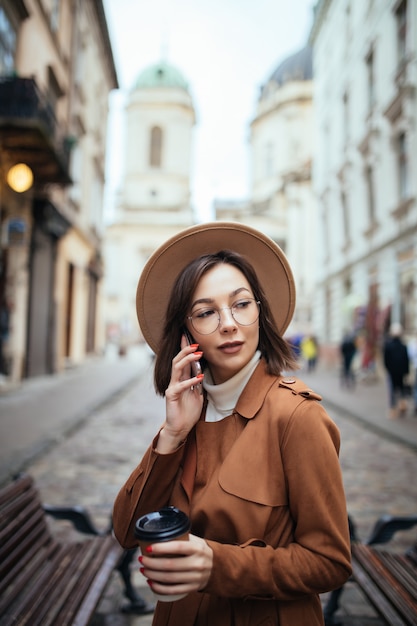 Beautiful Lady in Brown Coat Talking on Mobile Phone Outdoors in Autumn – Free Stock Photo for Download