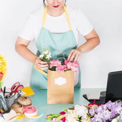 Female Florist Arranging Flowers in Paper Bag – Free Stock Photo for Download