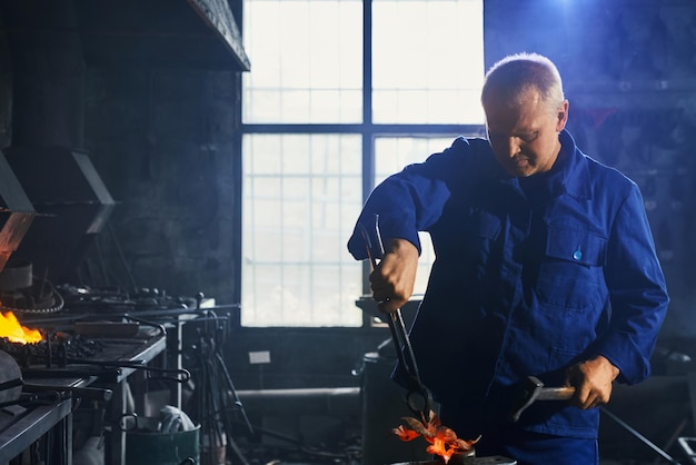 Man in Dark Blue Uniform Working with Hammer and Plier – Free Stock Photo for Download