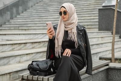 Modern Stylish Muslim Woman in Hijab, Leather Jacket, and Black Abaya Using Smartphone – Free Stock Photo, Download for Free