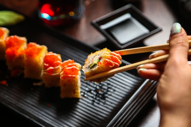 Woman Enjoying Fried Sushi with Chopsticks and Soy Sauce – Free Download