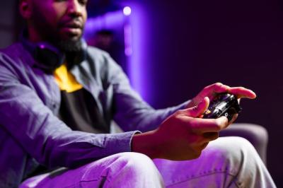 Gamer on Couch Playing Video Games with Controller and Headphones – Free Download