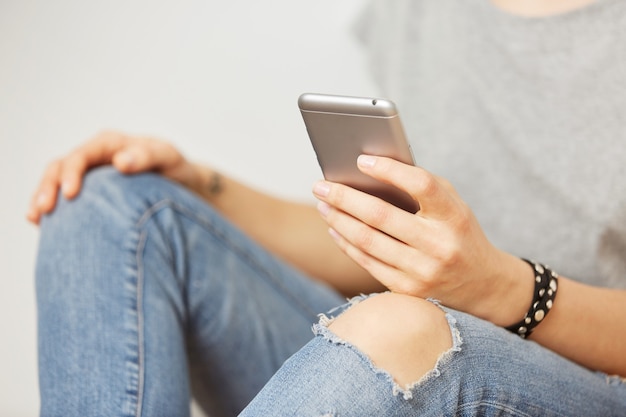 Beautiful Hipster Woman Checking Email on Mobile Against Grey Wall – Free Stock Photo Download