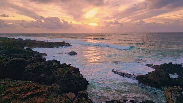 Turbulent Ocean Waves Breaking on Rocky Coast at Orange Sunset Glow – Free Stock Photo Download