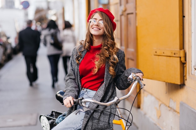 Smiling Curly Woman in Red Sweater Riding Bicycle on a Cold Day – Free Stock Photo Download