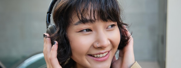 Beautiful Smiling Korean Girl in Headphones Enjoying a Day Out – Free Stock Photo for Download