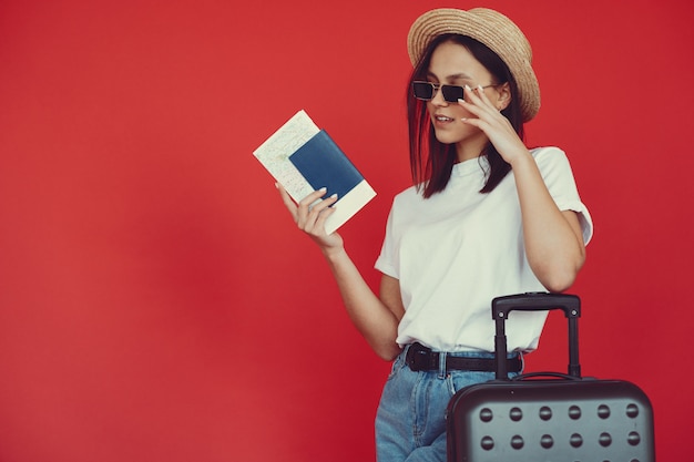 Chic Girl Posing with Travel Gear Against a Red Wall – Free Stock Photo, Download for Free