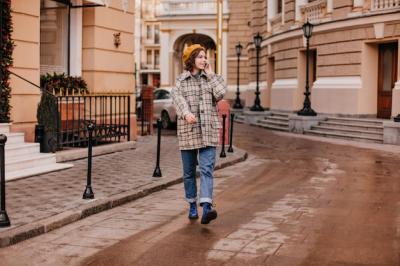 Portrait of a Stylish Woman in Jeans and Oversized Coat on a European Street – Free to Download