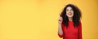 Excited Happy Attractive Woman with Curly Hair in Red Dress Raising Index Finger – Free Stock Photo for Download