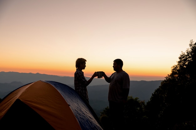 Two Happy Tourists at a Campfire on a Mountain – Free to Download