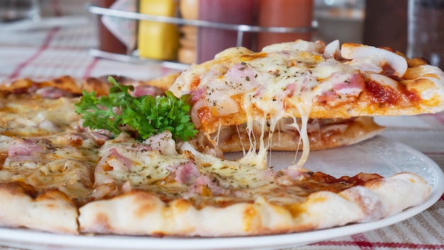 Delicious Family Lunch: Enjoying Pizza with Ham and Cheese – Free Download